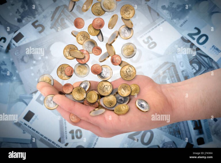 billetes y monedas apilados en mano abierta