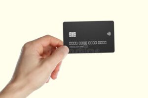 mano sosteniendo tarjeta de credito y luz