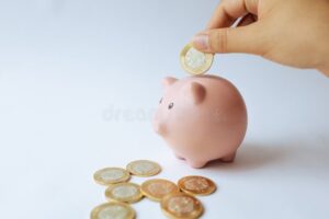 manos ahorrando monedas en cochinito mexicano