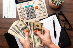 manos contando billetes y calculadora simple