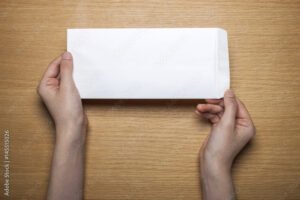 manos sosteniendo una carta sobre mesa wooden