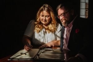 pareja sonriente firmando papeles matrimonio civil