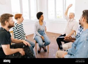 Cómo y Dónde Buscar Ayuda Cuando La Necesito Rápido 7 persona levantando la mano en grupo de apoyo