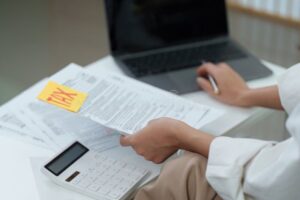 Cómo Crear Un Plan Efectivo Para Pagar Mis Deudas Rápidamente 14 persona organizando finanzas con calculadora y papeles