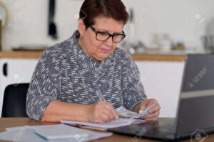 persona preocupada frente a computadora y documentos fiscales