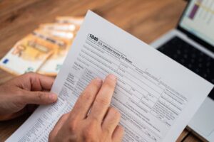 persona revisando documentos fiscales y computadora