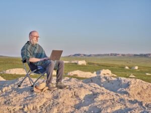 persona trabajando en computadora con paisaje mexicano