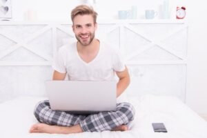 persona trabajando feliz desde casa en pijama