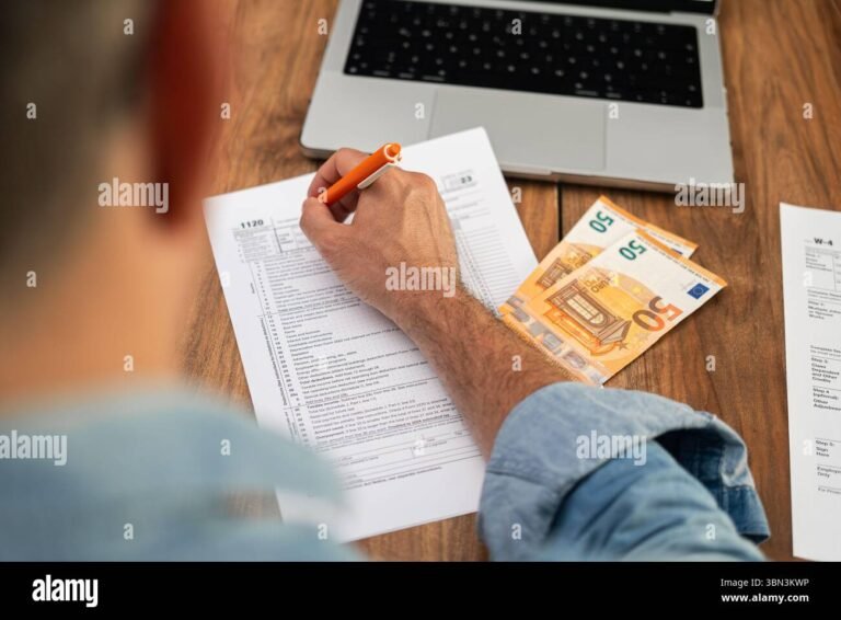 persona usando computadora para revisar documentos fiscales