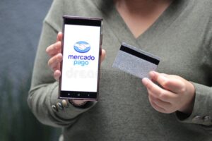 persona usando smartphone con logo mercado pago