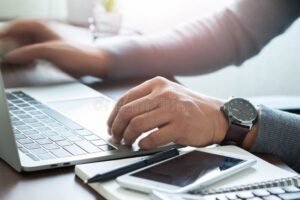 reloj de pulsera y manos trabajando en oficina