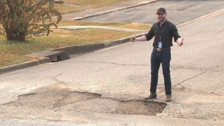 vecino senalando calle con baches grandes